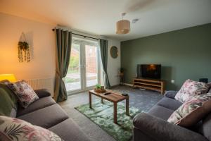 a living room with two couches and a tv at Einstein House By Horizon Stays in Stockton-on-Tees