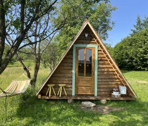 a small cabin with a pitched roof with two stools at Breb 220D glamping in Breb