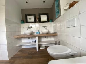 a bathroom with two sinks and a toilet at B&B Bakenberg in Arnhem