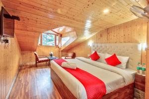 库尔卢Hotel Vijayant - By The Mount Heaven的小木屋内一间卧室,配有一张大床