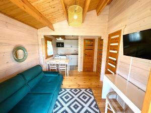 a living room with a blue couch and a kitchen at Pod Dziką Jabłonią in Debina