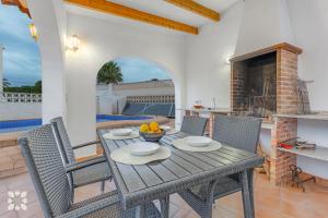 jadalnia ze stołem i krzesłami oraz kominkiem w obiekcie Villa Esmeralda by Abahana Villas w mieście Calpe