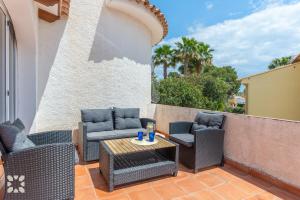 taras z wiklinowymi krzesłami i stołem w obiekcie Villa Esmeralda by Abahana Villas w mieście Calpe