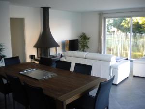 uma sala de estar com uma mesa de madeira e um sofá em Nokanhui em Soulac-sur-Mer