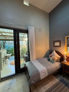 a bedroom with a bed and a view of a patio at The Treehouse Mtunzini in Mtunzini
