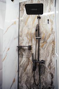 y baño con ducha y pared de piedra. en Hostel 1377, en Astana
