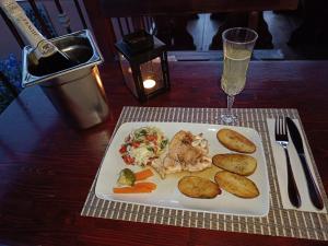 a plate of food on a table with a glass of wine at Pensiunea Mallorca Restaurant - Bar in Vişeu de Sus
