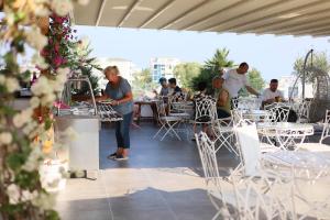 a group of people sitting at tables on a patio at Ilio Boutique Hotel in Ksamil
