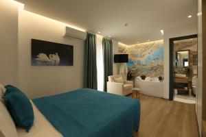 a bedroom with a blue bed and a bathroom at Ilio Boutique Hotel in Ksamil +37 photos