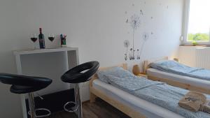 a bedroom with two twin beds and a stool at Panoráma 4U in Tapolca