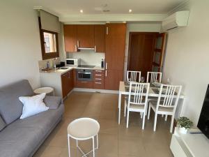 salon z kanapą, stołem i krzesłami w obiekcie Apartamentos Lanceata I w mieście A Lanzada