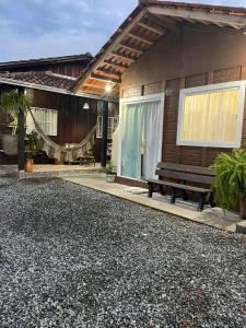 a house with a bench in front of it at Pousada do vô Bi 02 in São Francisco do Sul