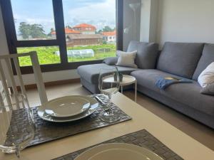 salon ze stołem i kanapą w obiekcie Apartamentos Lanceata I w mieście A Lanzada