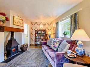 a living room with a purple couch and a fireplace at 2 bed in Blandford Forum STOMI in Durweston