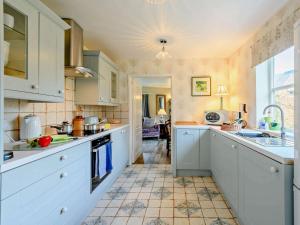 a kitchen with white cabinets and a tile floor at 2 bed in Blandford Forum STOMI in Durweston