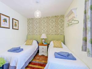 a bedroom with two beds and a night stand with a lamp at 2 bed in Blandford Forum STOMI in Durweston