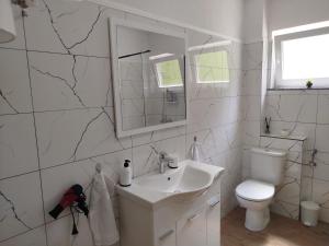 a white bathroom with a sink and a toilet at Apartman David in Jajce +33 photos