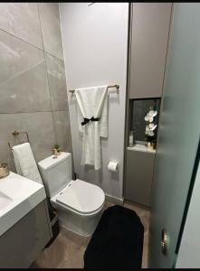 a bathroom with a white toilet and a sink at Dante One Rosebank Apartment in Johannesburg