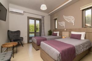 una habitación de hotel con dos camas y una silla en Villa Vatia 1, en Tragaki 24 fotos más
