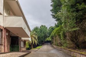 an empty road next to a building with trees at Aston - Villa Islas Urdaibai in Isla Becoa