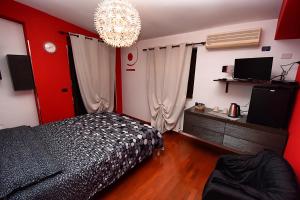 sypialnia z czarnym łóżkiem i żyrandolem w obiekcie B&B Agave 64 w mieście Piazza Armerina