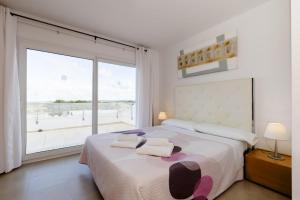 Un dormitorio con una cama grande y una ventana grande. en Villa Arual, en Arenal d'en Castell 44 fotos más