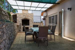 a patio with a table and chairs and a stone fireplace at Holiday Villa Anna in Primorski Dolac