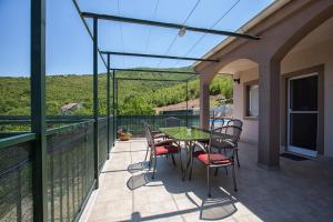 eine Terrasse mit einem Tisch und Stühlen auf dem Balkon in der Unterkunft Holiday Villa Anna in Primorski Dolac