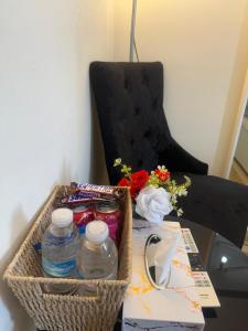 バーミンガムにあるThe Inn Premium Room For Family & Solo in Birminghamのテーブルの上には水のボトルと花が入ったバスケットがある