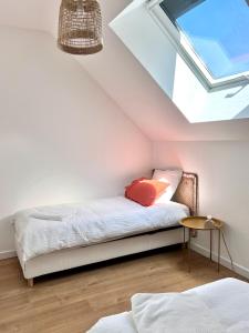 HeudicourtにあるMaison Origines - Escapade au vertのベッドと天窓のある屋根裏部屋の寝室
