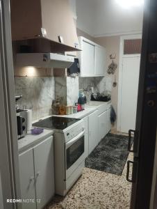a kitchen with white cabinets and a stove top oven at John's House in Chalkida