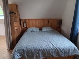 a bedroom with a bed with a blue comforter at Le Grenier in Saint-Christophe-sur-Condé +5 photos