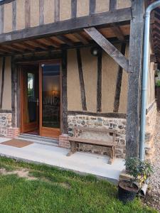 a building with a bench in front of a door at Le Grenier in Saint-Christophe-sur-Condé