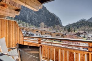 a balcony with chairs and a view of a town at Hotel habicher hof - Your 4-Star Superior Wellness Hideaway in Oetz