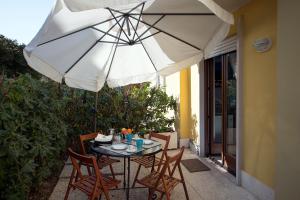 a table and chairs under an umbrella on a patio at Casa Vacanze RE.TI. in Arco