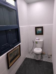 a bathroom with a white toilet and a window at Cat in the box homestay in Godown