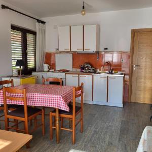 a kitchen with a table and chairs and a kitchen with white cabinets at Kozorog Durmitor in Žabljak
