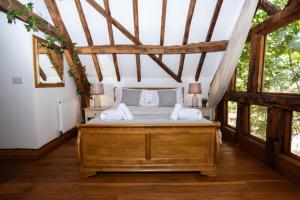 una camera da letto con un letto in una stanza con finestre di Treehouse Cottage Spa Retreat a Hereford