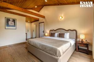 a bedroom with a large bed and a wooden ceiling at StayVista at Cujo's Haus with Heated Floor, Bonfire, WiFi, BBQ in Mukteshwar