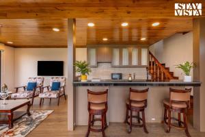 a kitchen and living room with a bar in a house at StayVista at Cujo's Haus with Heated Floor, Bonfire, WiFi, BBQ in Mukteshwar