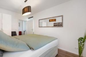 Un dormitorio con una cama y un espejo en la pared. en Ferienwohnung in München Eg, en Múnich