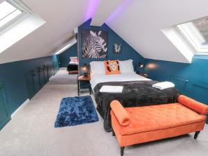 スカーバラにあるLawnswoodの青い壁とオレンジ色のソファのあるベッドのある寝室