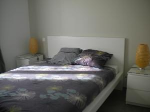 a bed in a bedroom with two night stands and two lamps at Nokanhui in Soulac-sur-Mer