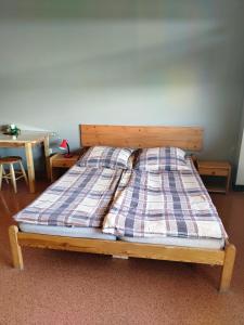 ein Bett mit einer karierten Decke darüber in der Unterkunft Pokoje Gościnne Grzybowo in Grzybowo