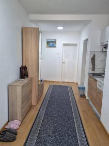 a room with a kitchen with a rug on the floor at Apartman CENTAR 1 in Jajce +5 photos