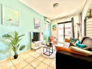 a living room with a couch and a tv at LE COSY Canet - Studio pour 2 personnes à 30m de la plage avec parking in Canet-en-Roussillon +16 photos