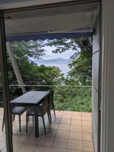 a table and chairs on a balcony with a view at Villa 波音テラス vacation club in Ito