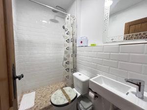 a white bathroom with a toilet and a sink at PUSHE Village Albayzin Art & Culture in Granada +38 photos