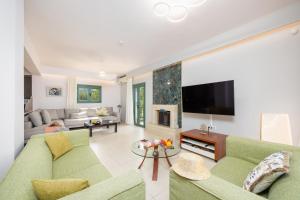 ein Wohnzimmer mit Sofa und Fernseher in der Unterkunft Villa Kyveli in Loutra