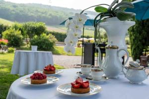 a table with desserts on plates and a vase with flowers at Villa Saint-Lager - Séjour de charme au cœur du Beaujolais in Saint-Lager